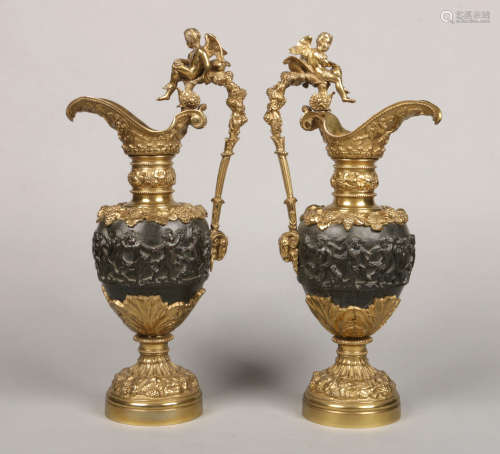 A large pair of gilt and patinated bronze Classical style ewers. Each handle surmounted by a