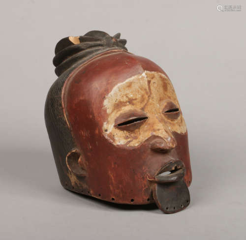 A West African carved hardwood tribal helmet mask. With polychrome and kaolin pigment decorations
