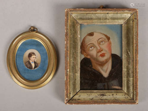 A 19th century reverse painted portrait miniature on glass of a monk in silvered frame along with