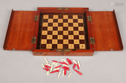 A mahogany folding chessboard with rosewood and maple parquetry inlay along with a carved and