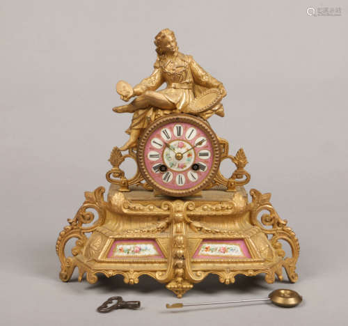 A 19th century French gilt metal mantel clock. Set with pink ground Sevres style panels painted with