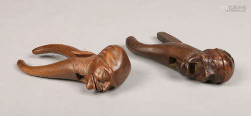 Two Black Forest carved figural lever action nut crackers. Each decorated with the head of and