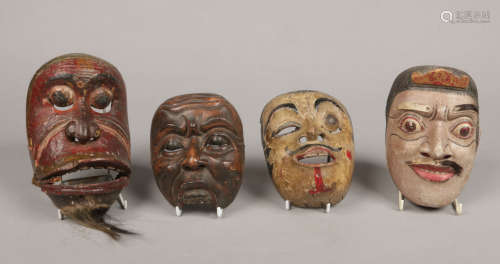Three Japanese carved polychrome wood Noh (theatre) masks and a similar Burmese mask. Largest