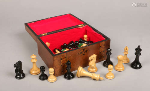 A carved and ebonized wooden chess set of Staunton style with weighted pieces in Victorian walnut