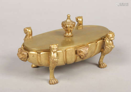 An early 20th century French bronze desk stand and cover. Housing a pair of inkwells, with ram masks