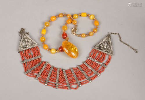 An eastern white metal and coral bead multi row necklet and a butterscotch amber bead necklace