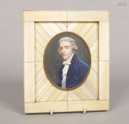 An ivory portrait miniature of a gentleman wearing a blue overcoat and cravat in large piano key