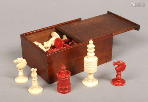 An early 20th century Indian export bone and ivory polychrome chess set in mahogany box with sliding