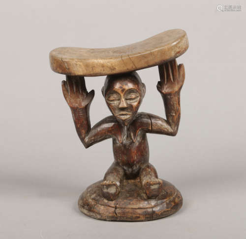 A West African tribal carved hardwood figural headrest, 22cm.