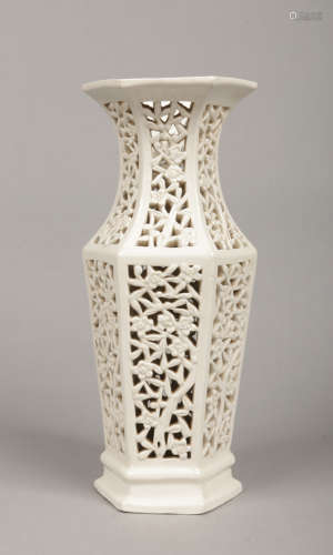 A Chinese blanc de chine pierced hexagonal baluster vase. Decorated with panels of pierced prunus