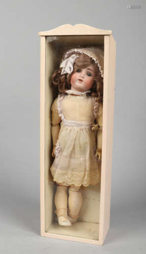 A 19th century German bisque headed doll with jointed composite body in display case.