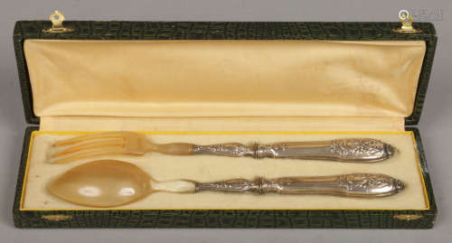 A cased pair of French horn salad servers with silver mounted handles. Minerva punch marks.Condition