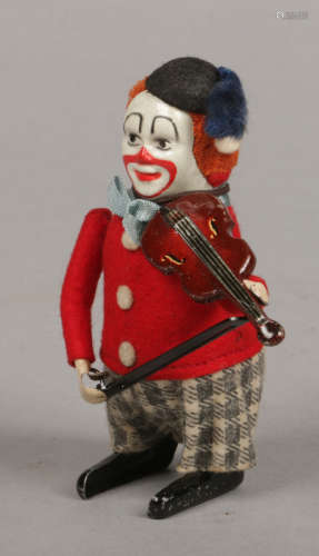 A Schuco clockwork model of a clown playing a violin. Stamped Schuco, made in Germany, 11cm.