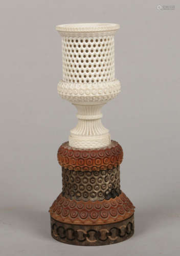 A 19th century Anglo Indian carved and reticulated ivory urn raised on a sandalwood and hardwood