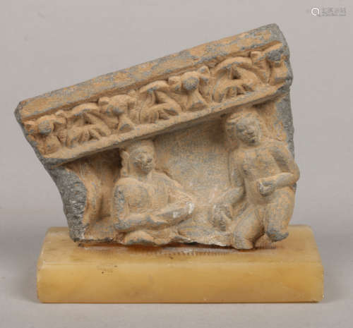 A small Ghandara stone fragment incorporating figures and raised on an associated onyx plinth, 11.