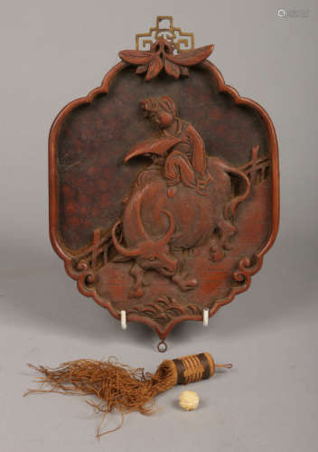 A Chinese carved fruitwood wall hanging. Decorated in relief with a figure riding on a water