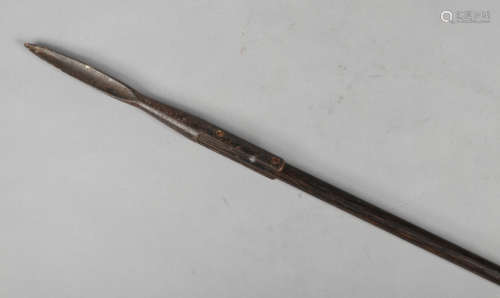 An African spear with triangular blade, weighted to the centre and with geometric carvings, 148cm.