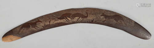 An Aboriginal hardwood boomerang. Carved in light relief with kangaroos and emus in a landscape,