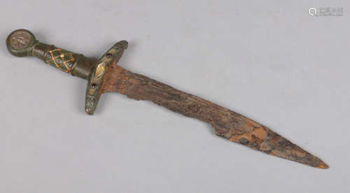A European medieval dagger with bronze hilt and fullered blade. Set with two silver coins to the