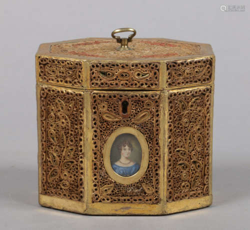 A Regency tea caddy of canted rectangular form. Decorated with panels of rolled paper and set with a