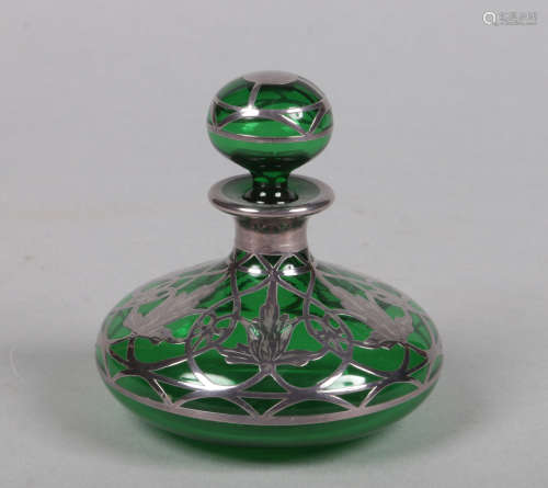 An Art Nouveau green glass scent bottle and stopper with openwork silver mounts, 9cm high.