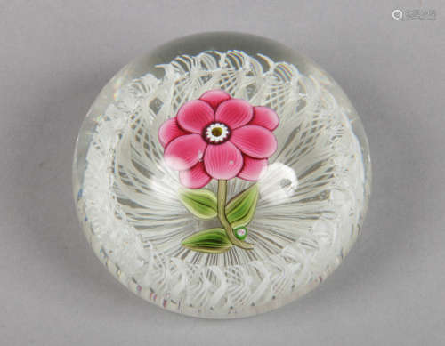 A Paul Ysart glass paperweight decorated with a single flower over a white stave basket. Signed, 7.