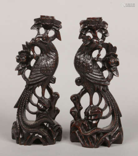 A pair of Chinese hardwood carvings each formed as a stylized phoenix, 31.5cm.