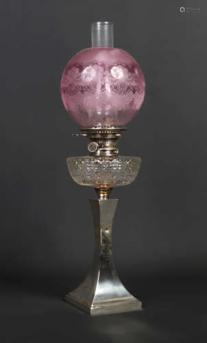 An Edwardian silver based oil lamp of square tapering form. With etched cranberry tint shade, cut