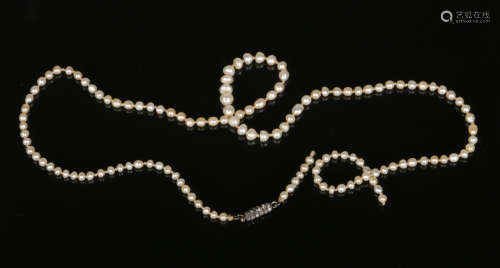 A cased string of graduated natural saltwater pearls of semi baroque shape and with white metal