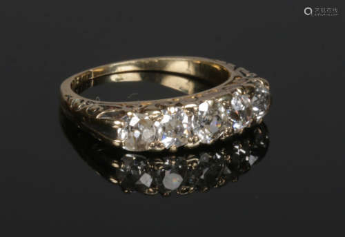 An 18 carat gold 5 stone diamond ring. Set with five graduated old European cut diamonds