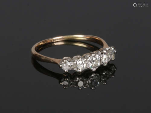 A gold five stone diamond ring. Set with a line of five graduated old European cut diamonds,