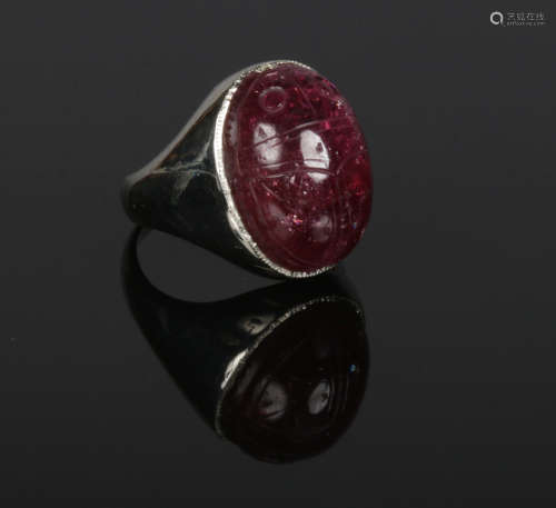 An 18 carat white gold ring set with a large antique carved tourmaline scarab beetle. 14.69 grams,