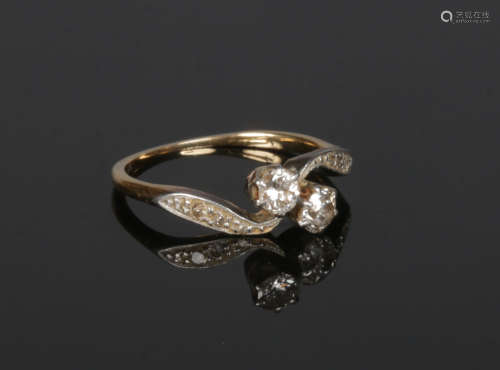 A gold diamond crossover ring. Set with two round cut diamonds approximately 0.2ct each and with