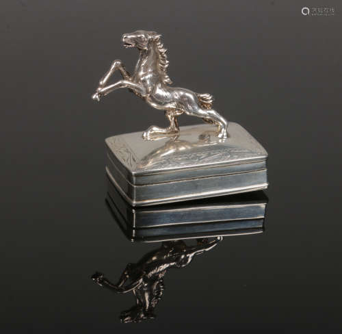 A silver trinket box with hinged cover. Surmounted with a cast silver model of a rearing horse and