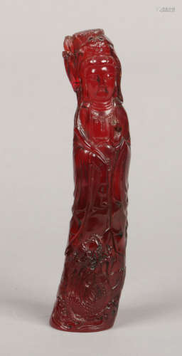 A Chinese carved cherry amber coloured statue of Guanyin. Dressed in flowing robes and holding a