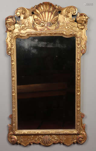 An antique Irish giltwood hall mirror. The pediment with eagle masks and swan neck scrolls is
