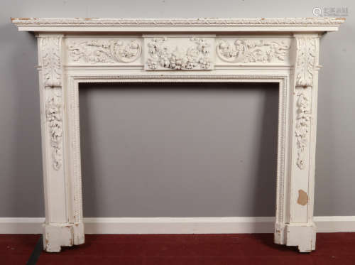 A painted carved pine carved fire surround. With gadrooned mouldings, and decorated with flower