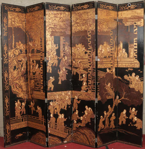A very large early 20th century Chinese twelve fold lacquered screen. Decorated over a gilt ground