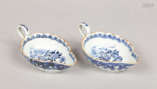 A pair of 18th century Chinese export fluted blue and white sauceboats. With scrolling loop
