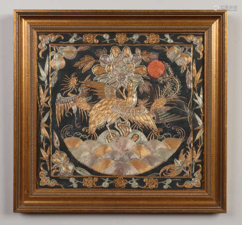 A gilt framed Chinese silk rank badge with gold and silver thread and depicting a crane and