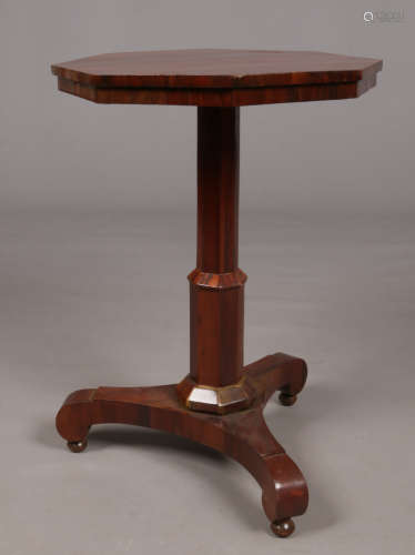 A Regency style rosewood centre pedestal table. With hexagonal top and raised on three scroll