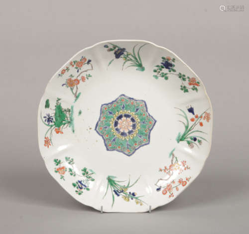 A Chinese Kangxi (1662-1722) scalloped famille verte dish. Painted with flower specimens to each