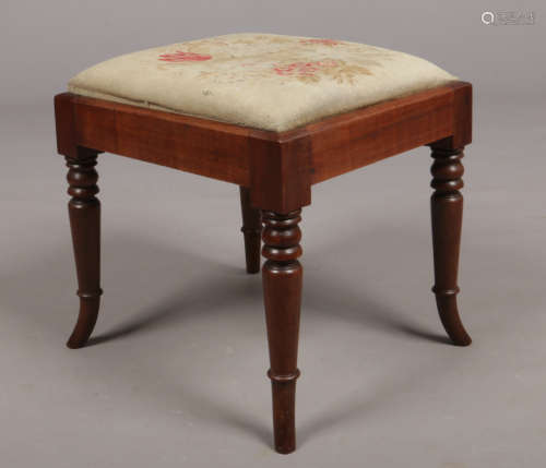 A Regency mahogany stool with needlepoint inset seat. Raised on ring and bobbin turned supports with