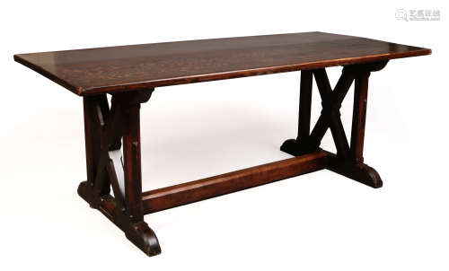 An Arts and Crafts oak refectory dining table raised on X-frame supports, 195cm x 89cm.