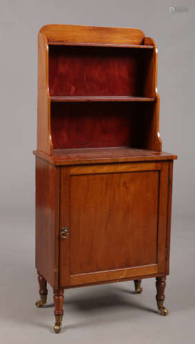 A 19th century mahogany waterfall bookcase of small proportions. Raised over a cupboard base with