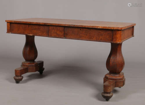 An early 19th century pollard oak library table. With two drawers concealed in the frieze and raised