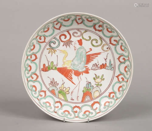 A Chinese polychrome dish painted with a sage riding upon a crane in a landscape under a stylized