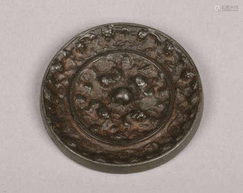 An antique Japanese small bronze mirror of circular form. Decorated in relief to the reverse, 7.