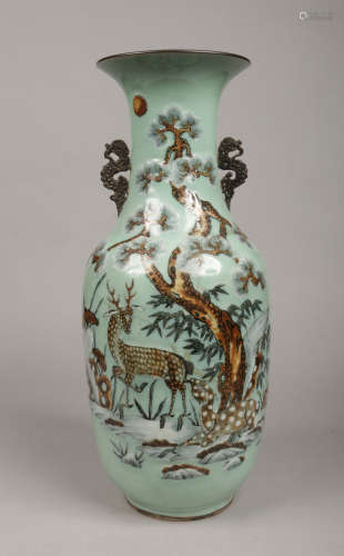 A 19th century Chinese celadon floor vase of baluster form and having flat stylized dragon