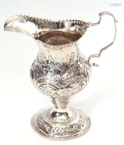 George III milk jug of baluster form with shaped rim, cast and applied leaf capped handle and body